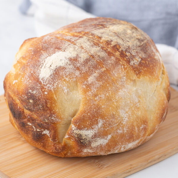 Image of a white sourdough boule placed on a cutting board.
