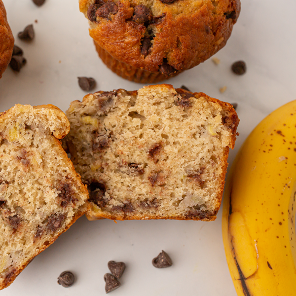 A platter of warm fresh banana chocolate chip muffins sliced in half and garnished with semi sweet chocolate chips.