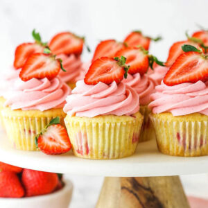 Strawberry Lemonade Cupcakes garnished with fresh strawberries.